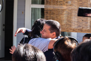 Superintendent Alberto Carvalho embraces a student during a home visit