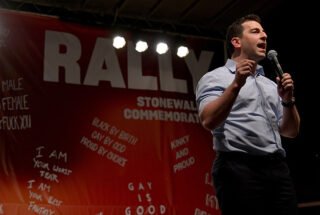 Amit Paley stands speaking and holding a microphone