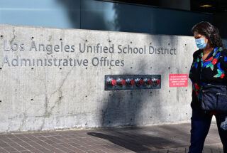 A pedestrian walks past the headquarters of the Los Angeles Unified School District