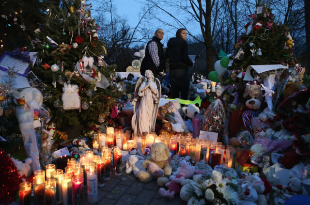 A news photo of people gathered at dusk at a memorial for the victims of the Sandy Hook shooting.