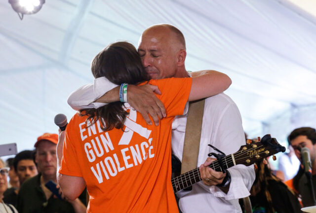 Mark Barden hugs his daughter Natalie; her shirt says End Gun Violence on the back