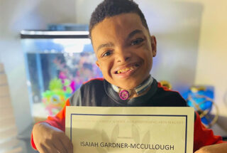 A photo of Isaiah holding a certificate