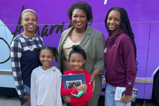LaToya Brooks and her three daughters post for a photo with Georgia gubernatorial candidate Stacey Abrams in front of her campaign bus
