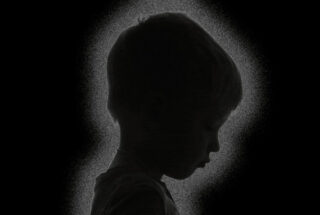A conceptual image showing the silhouette of a little boy on a black background