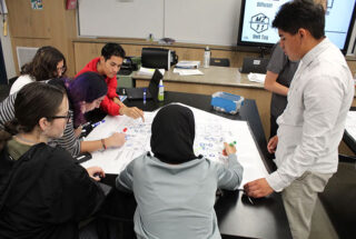 A small group of students work together around a table