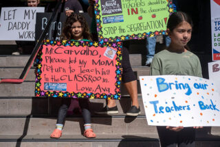 Protesters hold signs about the vaccine mandate. A child's sign says Mr. Carvalho, Please let my mom return to teaching in the classroom.